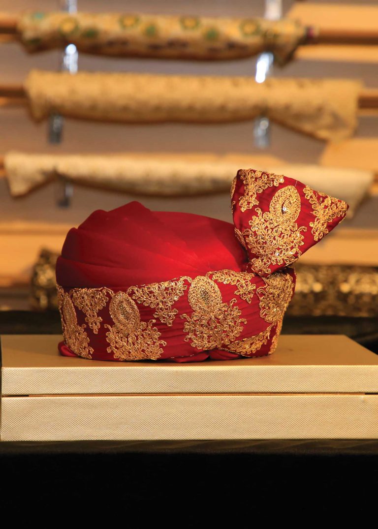 Man wearing a red turban at a royal wedding