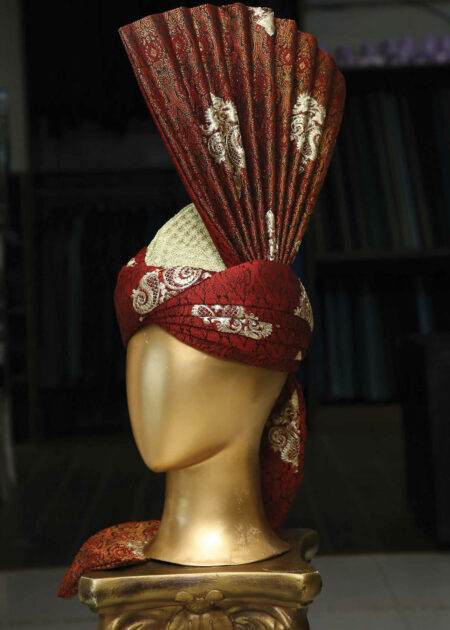 A person wearing a vibrant Crimson Silk Turban.